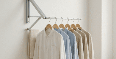 Colgador de ropa plegable instalado en una pared de hogar moderno, con prendas colgadas y espacio optimizado