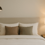 Lámparas de pared instaladas a los lados de la cama en un dormitorio moderno con luz cálida y decoración minimalista