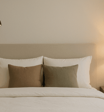 Lámparas de pared instaladas a los lados de la cama en un dormitorio moderno con luz cálida y decoración minimalista